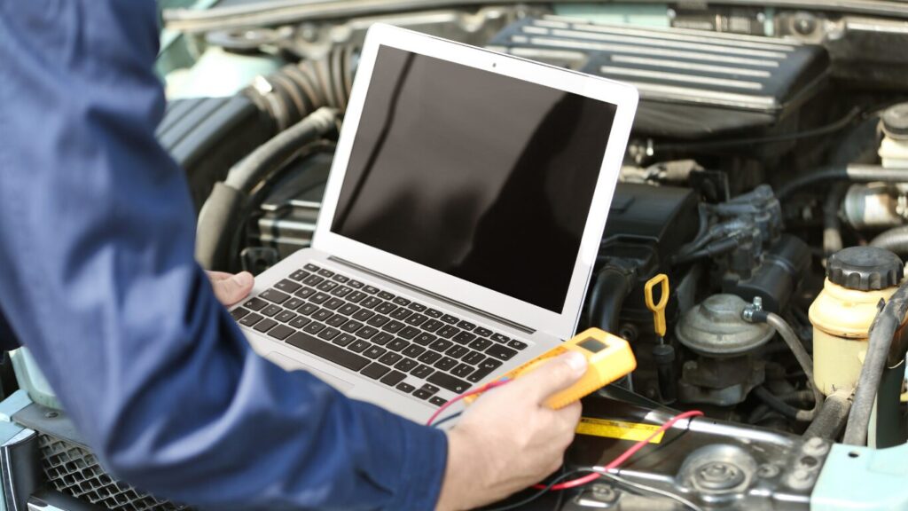 Monteur voert auto diagnose uit met laptop en multimeter nabij Zwanenburg voor technische storingsoplossing.