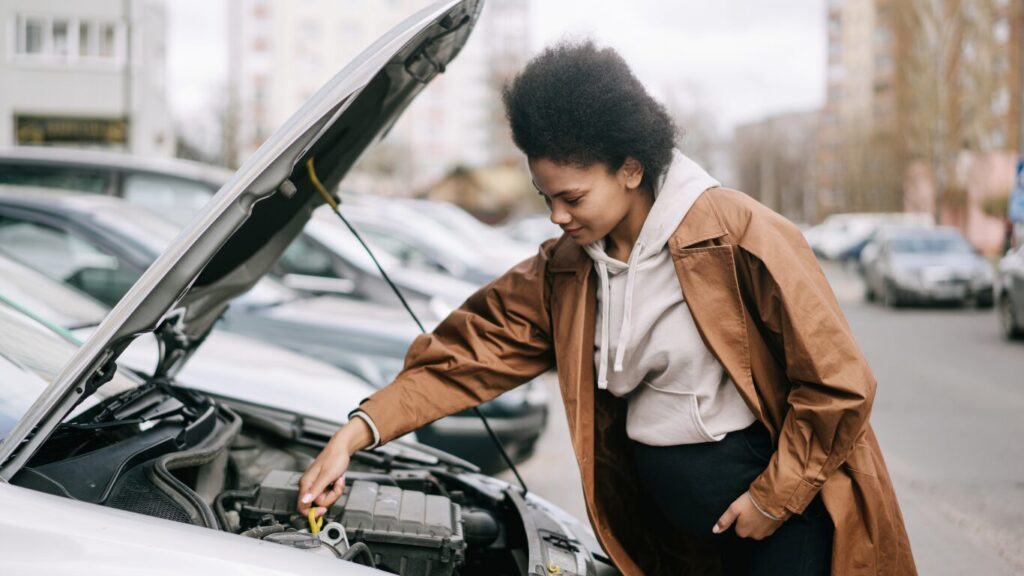 Bestuurder controleert oliepeil als voorbereiding op APK keuring in Zwanenburg